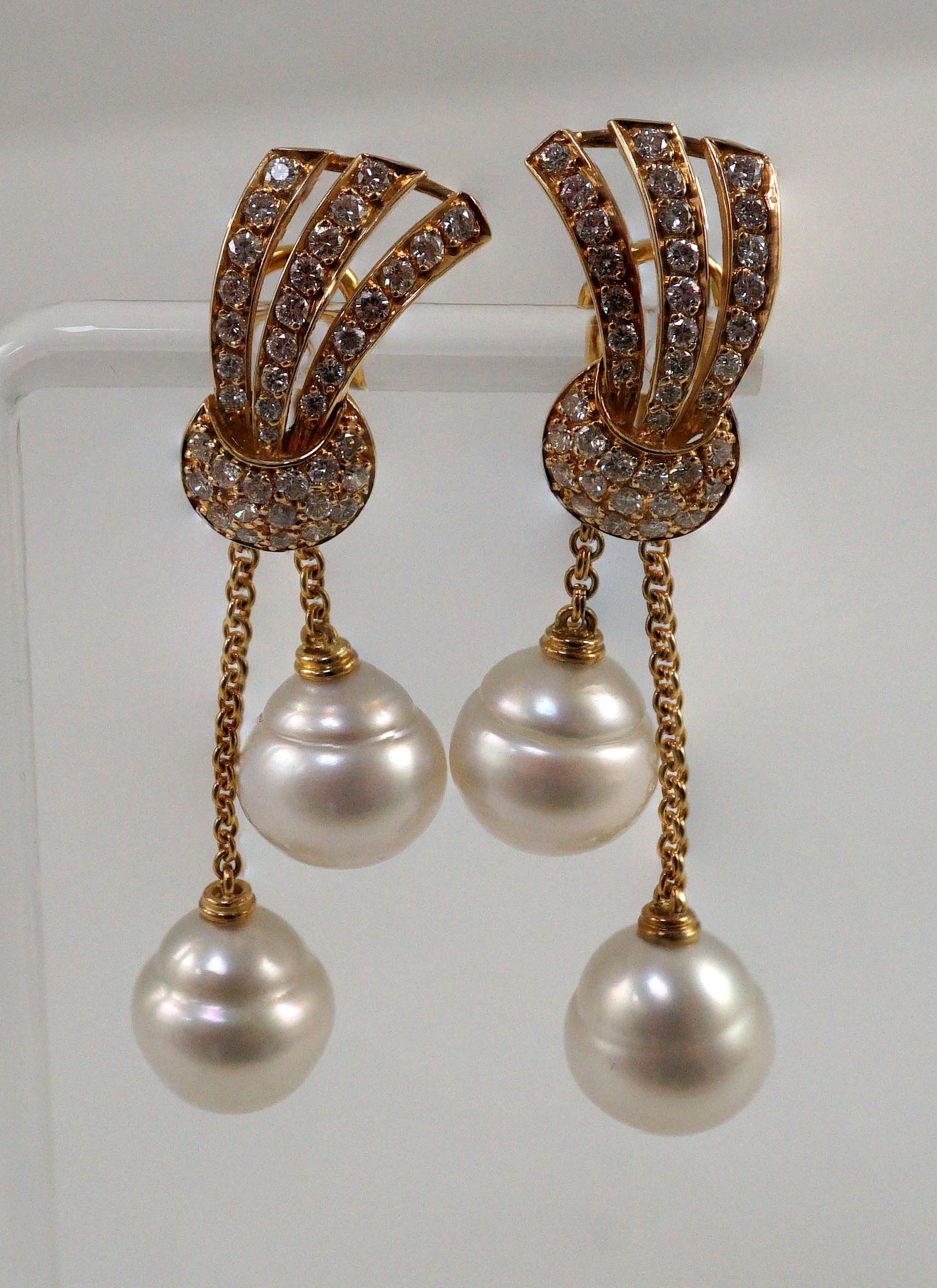 A modern pair of gold (tests as 18ct) and two stone South Sea pearl and diamond cluster set double drop earrings